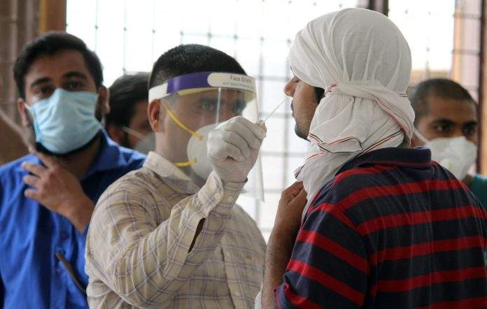 A health worker collects swab sample for Covid-19 rapid antigen testing